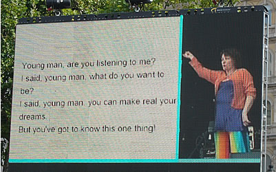 Picture of the large screen which was set up on the left of the stage. Caroline is on the right, and the words of the YMCA song are on the left.